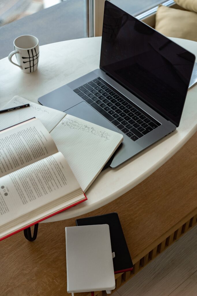 laptop, coffee cup and books on the table